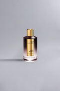A sleek bottle of Aoud Vanille Dark Purple fragrance with a gradient dark purple to clear glass design and a shiny gold cap against a light gray background.