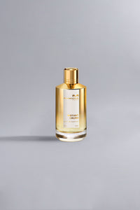 Instant Crush Gold perfume bottle with a sleek gold cap and liquid inside, showcased against a minimalist gray background highlighting its luxury and high fashion appeal.