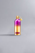A luxury perfume bottle with a metallic gradient finish transitioning from dark purple at the top to gold at the bottom, labeled Orchid Powder Dark Purple.