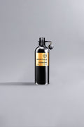 Sleek black bottle with gold label displaying Oudmazing Black, a luxury high fashion fragrance from Maastricht, standing on a neutral light gray background.