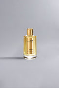 Elegant bottle of Sicily Gold perfume with golden liquid and cap, set against a neutral gray background showcasing luxury fragrance design