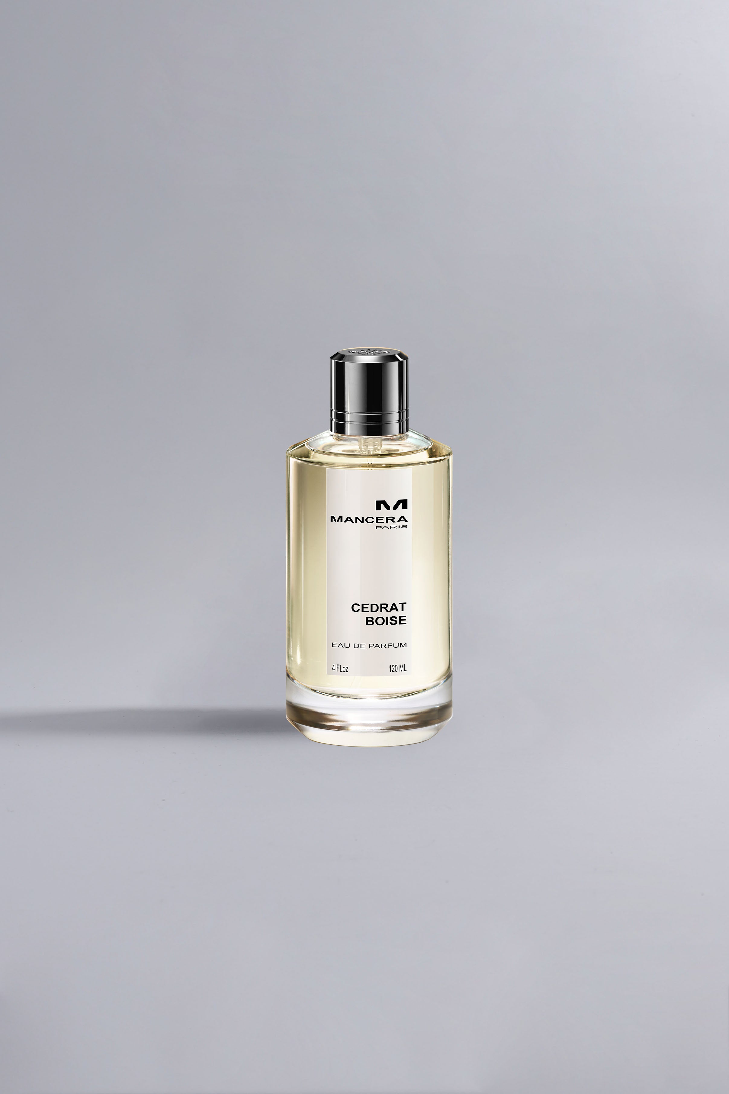 Elegant glass bottle of Cedrat Boise Yellow Dessin perfume with pale yellow liquid and black cap displayed against a soft gray background.