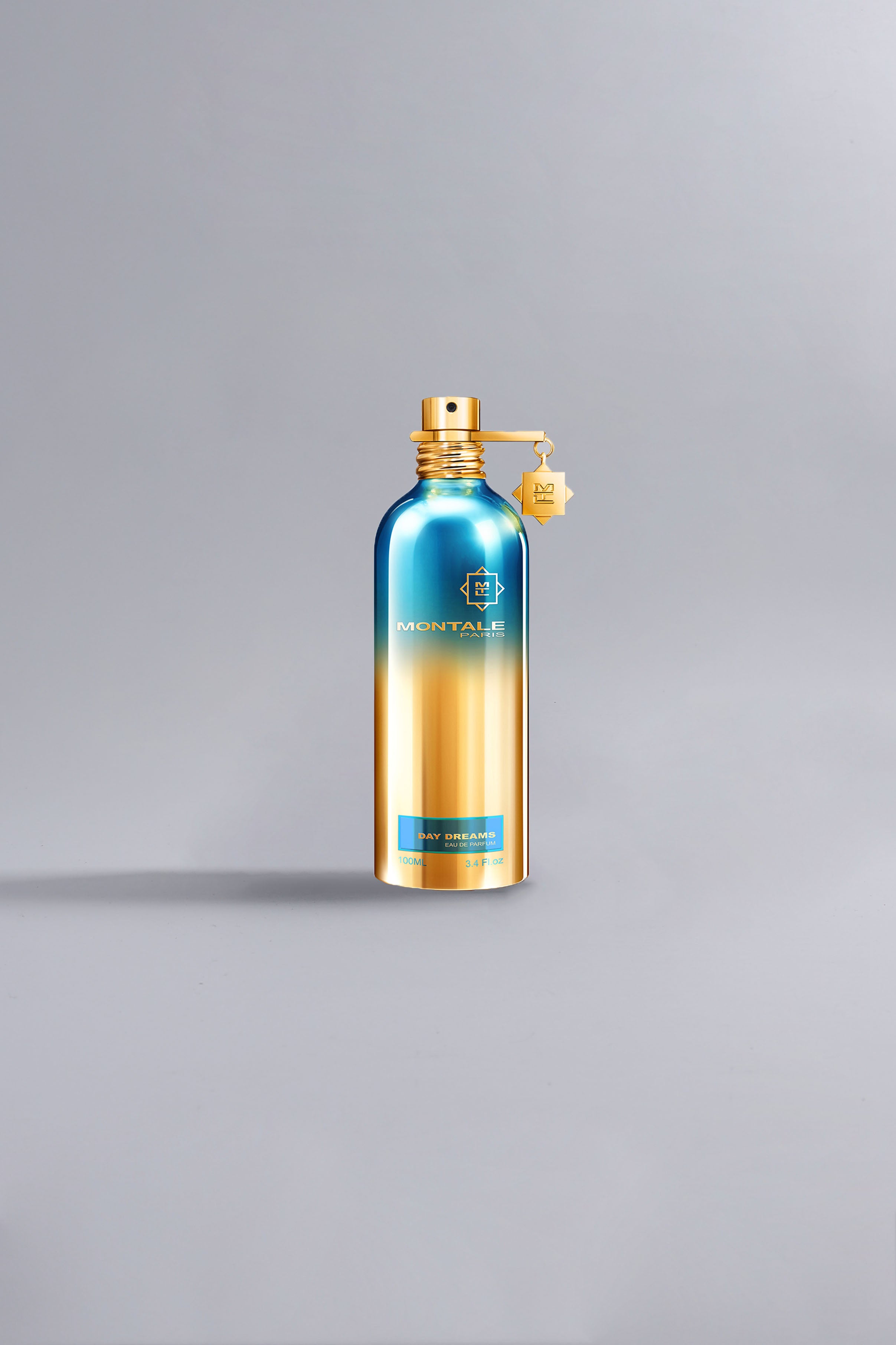 Luxury Montale perfume bottle with a blue and gold gradient design, labeled Day Dreams Green, standing on a light gray background.