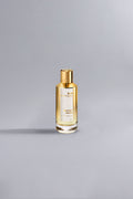 Luxurious gold-accented perfume bottle labeled Instant Crush Gold standing on a smooth gray surface, showcasing elegant high fashion design.