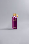 Elegant metallic spray bottle in rich dark purple with gold accents, showcasing the Intense Café Dark Purple fragrance from Montale, embodying luxury and high fashion.