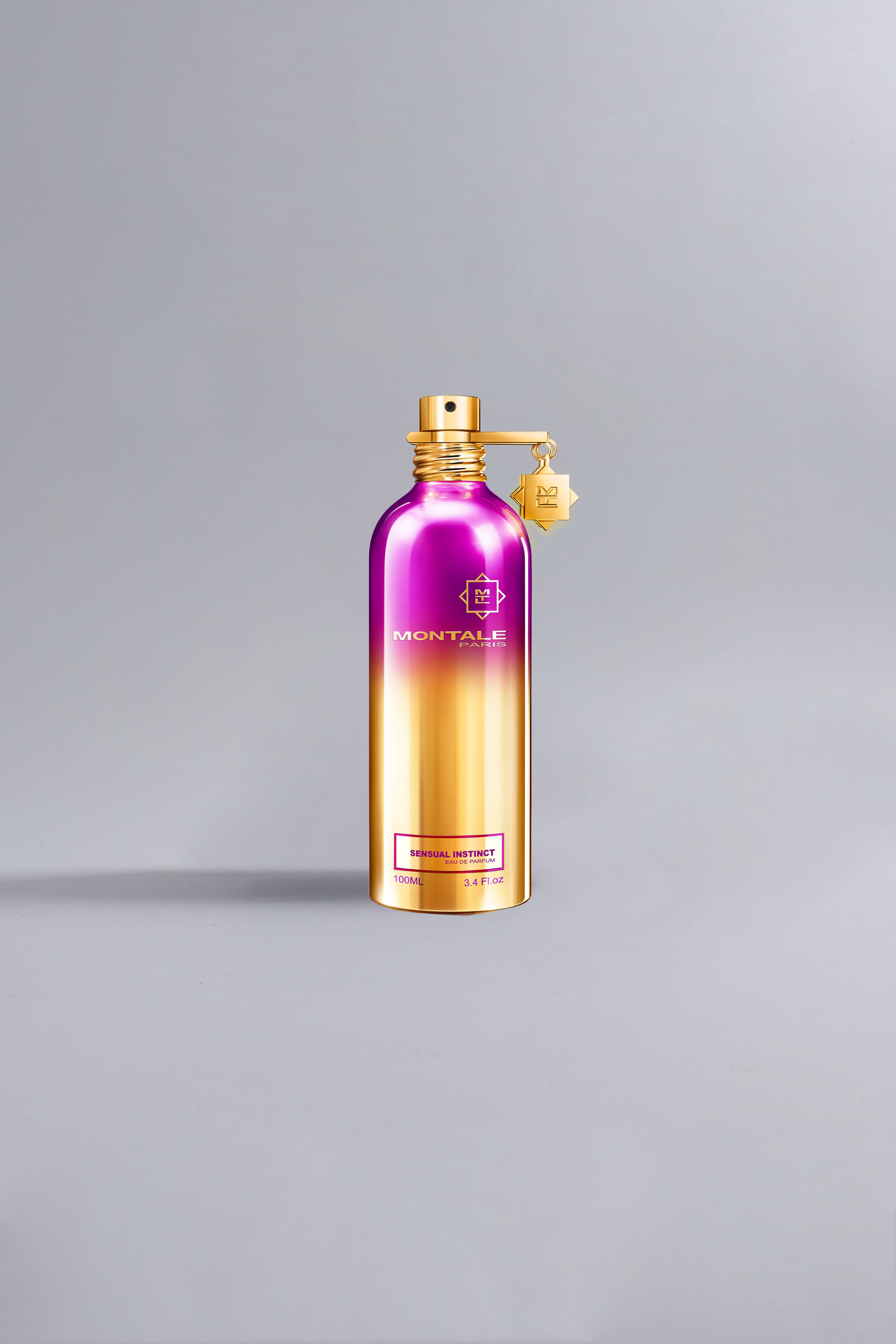 Metallic purple and gold Montale perfume bottle standing on a light grey background, featuring the label Sensual Instinct Purple.