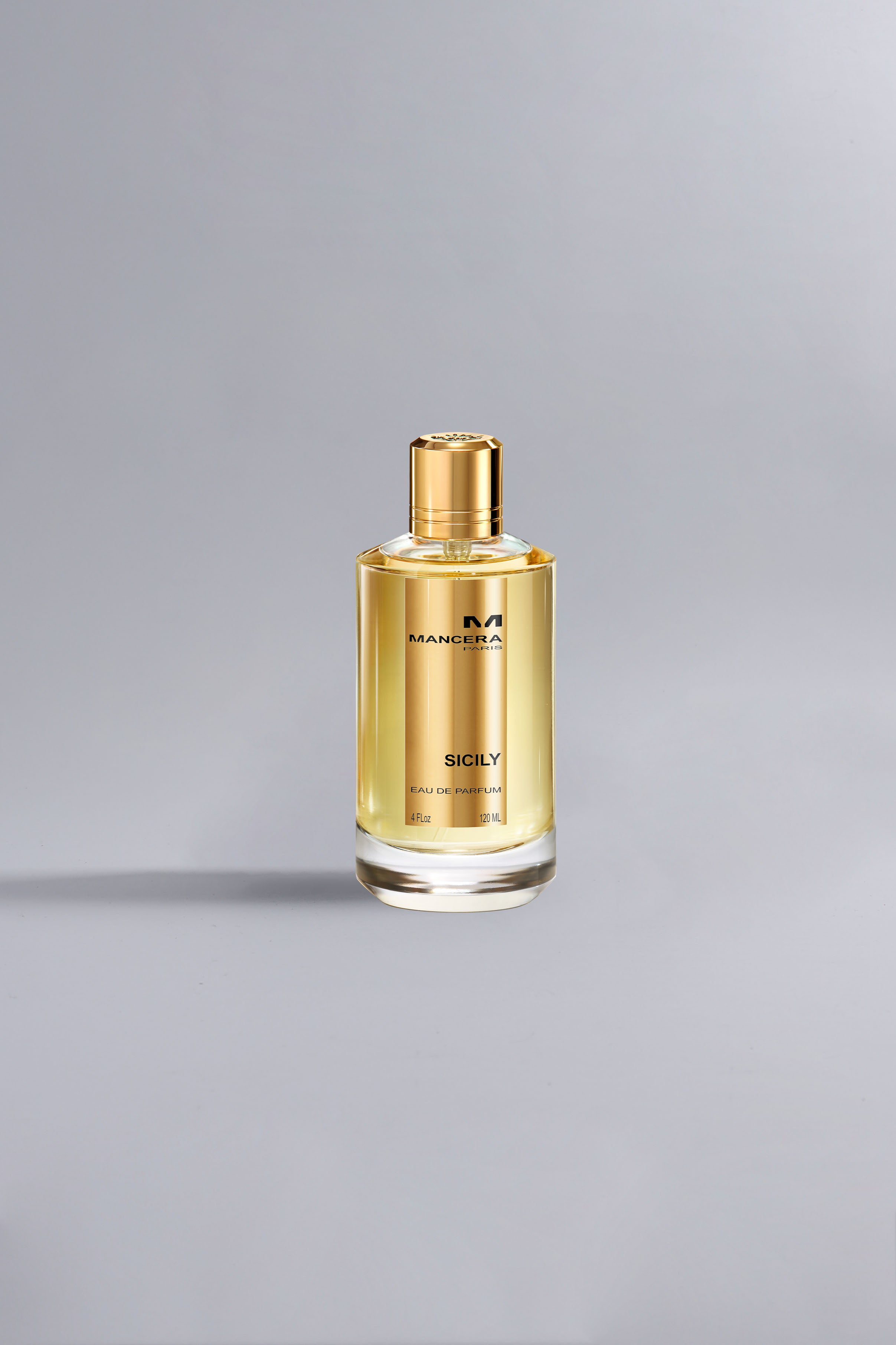 Elegant bottle of Sicily Gold perfume with golden liquid and cap, set against a neutral gray background showcasing luxury fragrance design
