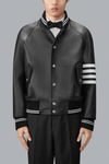 Black leather varsity jacket with white stripes on sleeves against a gray background