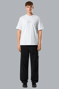 Person wearing a white t-shirt and black pants on a gray background