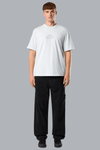Person wearing a white t-shirt and black pants on a gray background